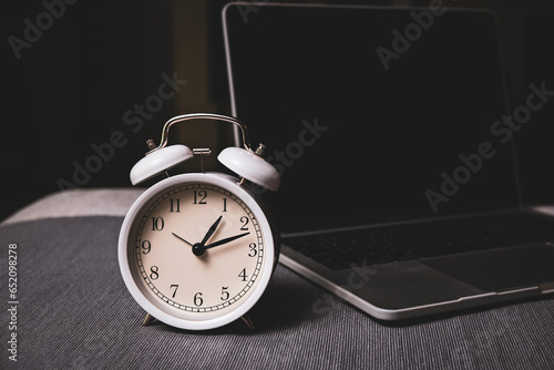 The clock and laptop for work life balance concept and time manage meant . dark mode