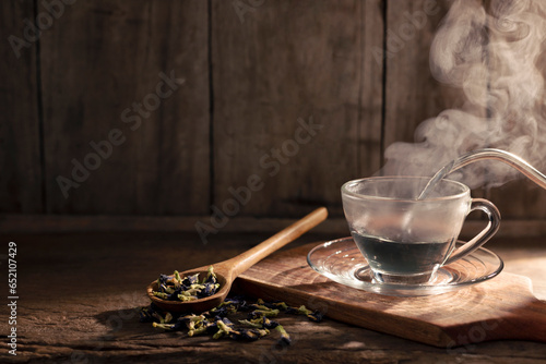 Cups of hot butterfly pea tea are arranged on a wooden floor. Healthy Herbal Drink Concept Traditional Antioxidant Drinks