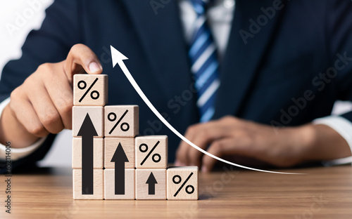 Financial interest rates and dividends provision of financial services. Businessman touching wooden block with percentage symbol and up arrow. Interest Rates Stocks Finance Ratings Mortgage Rates.