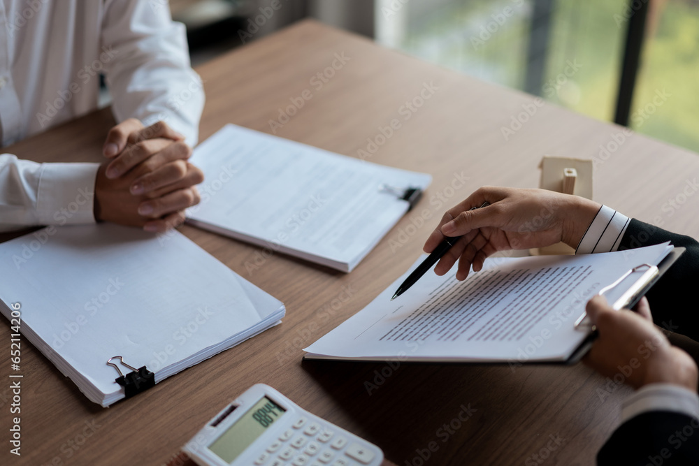 Real estate agent woman pointing with pen on house purchase contract for customer signing signature Real estate agent woman pointing with pen on house purchase contract for customer signing signature
