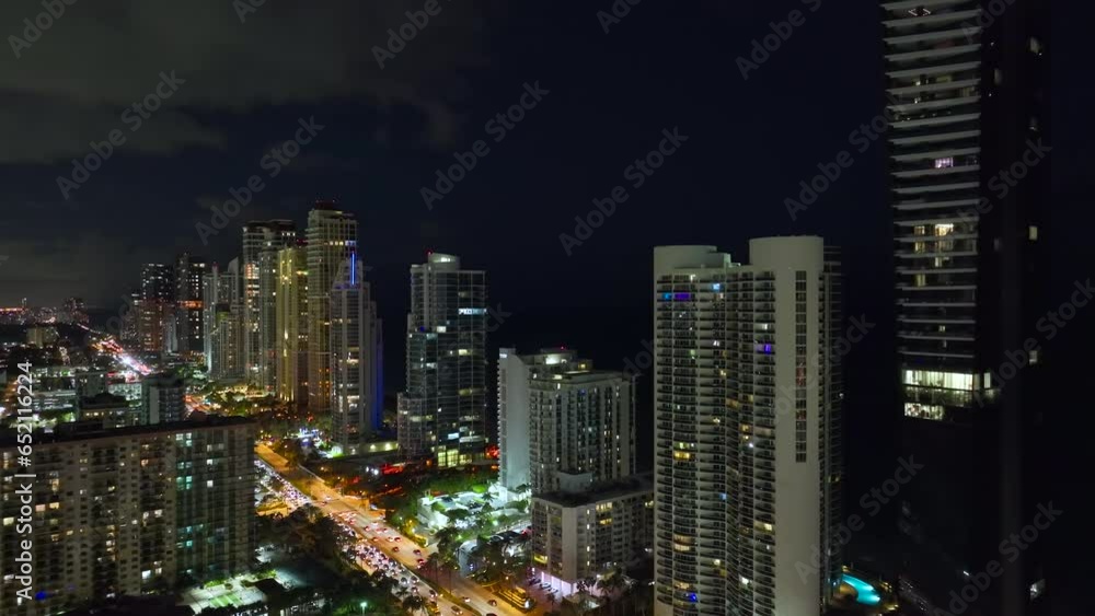 Night urban landscape of downtown district in Sunny Isles Beach city in Florida, USA. Skyline with brightly illuminated streets and high skyscraper buildings in modern american megapolis Night urban landscape of downtown district in Sunny Isles Beach city in Florida, USA. Skyline with brightly illuminated streets and high skyscraper buildings in modern american megapolis