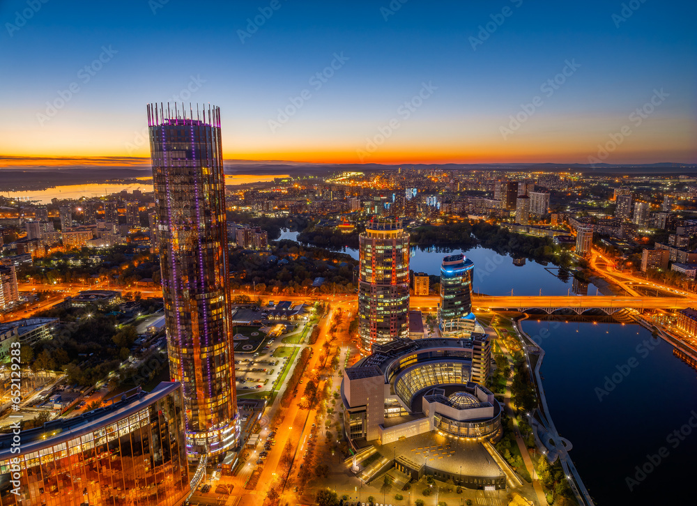 Obraz premium Yekaterinburg city and pond aerial panoramic view at summer or early autumn night. Night city in the early autumn or summer.