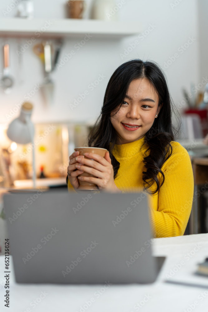 Young Asian businesswoman working using laptop computer on desk at freelance home. Relax. Stretching. Lifestyle of women studying and doing business online business and education concept Young Asian businesswoman working using laptop computer on desk at freelance home. Relax. Stretching. Lifestyle of women studying and doing business online business and education concept