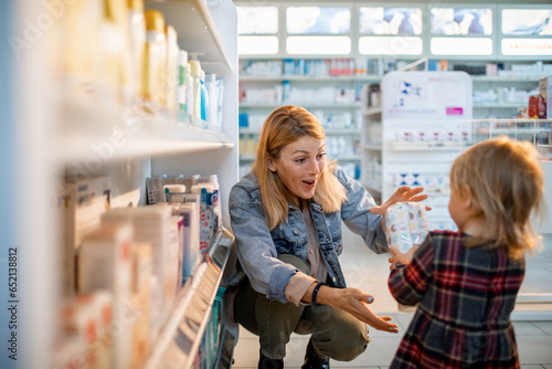 Happy young caucasian mother and daughter in a pharmacy photo
