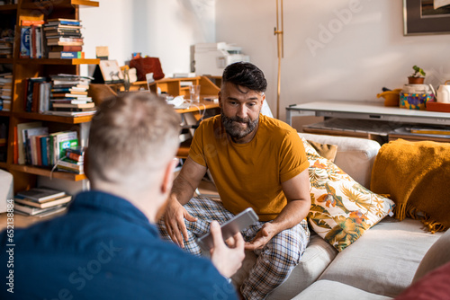 Young male gay couple arguing over a text or photo involing cheating and being unfaithful
