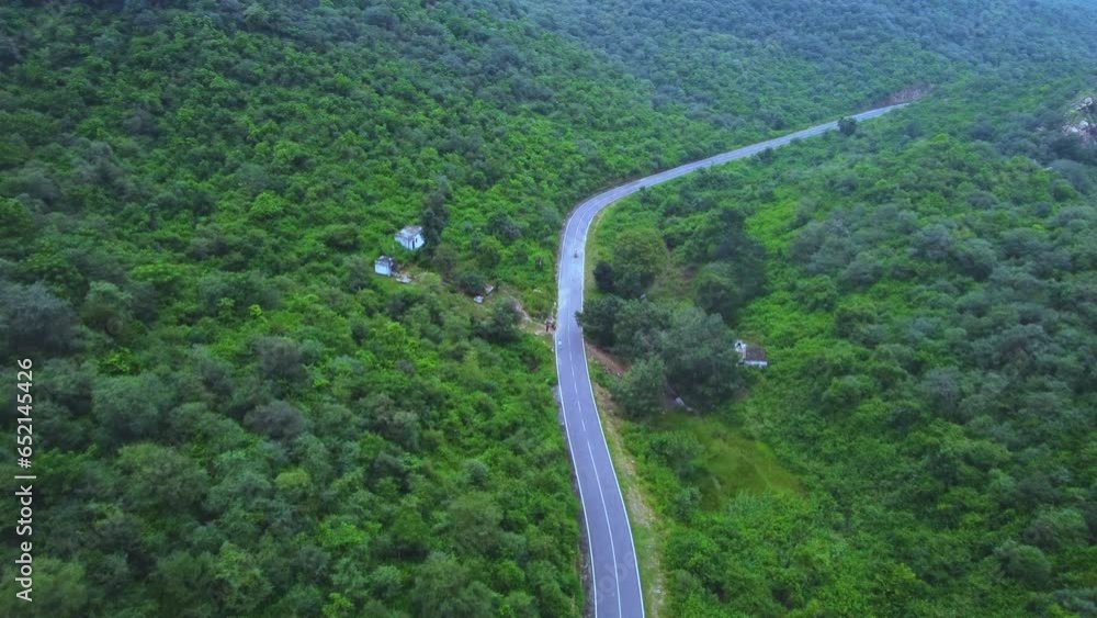 Aerial Drone view of a motor bike on forest road through lush green Jungle with hilly backdrop during monsoon in Gwalior Madhya Pradesh India Aerial Drone view of a motor bike on forest road through lush green Jungle with hilly backdrop during monsoon in Gwalior Madhya Pradesh India