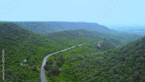 Aerial Drone view of a road through forest lush green Jungle with hilly backdrop during monsoon in Gwalior Madhya Pradesh India photo