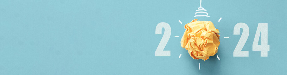 2024 Yellow paper light bulb, innovative business vision and  new year resolution goal, energy efficiency concept