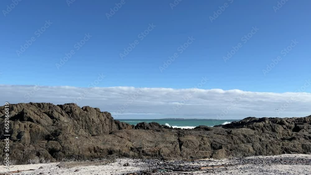 Waves smashing against big beach boulders Waves smashing against big beach boulders