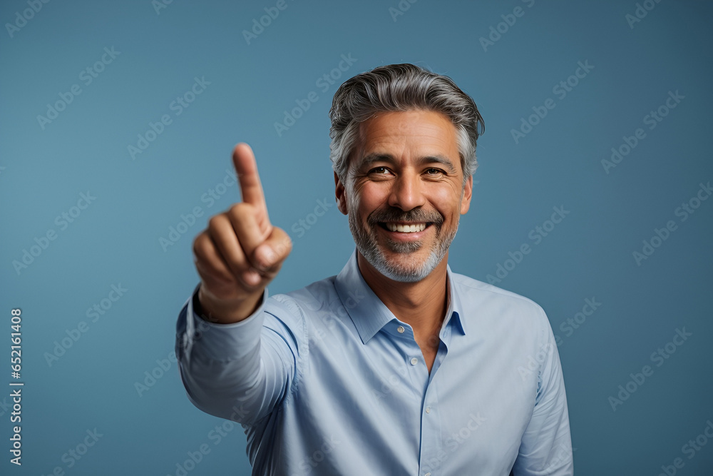 Portrait of cheerful businessman pointing at copy space for advertising against blue background Portrait of cheerful businessman pointing at copy space for advertising against blue background