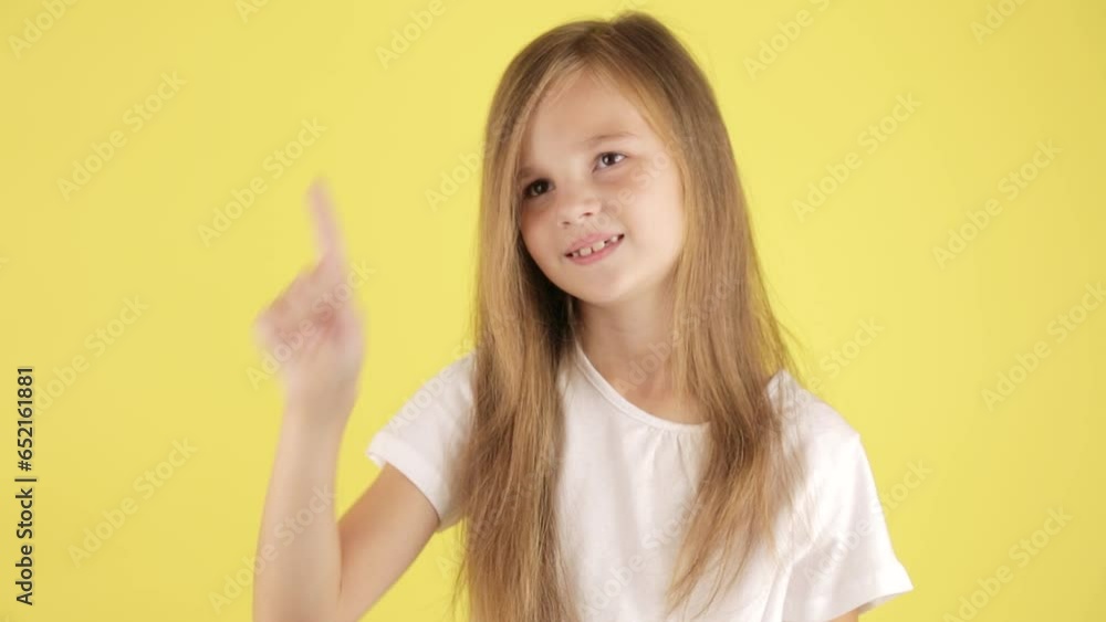 Portrait of funny little preteen girl make gesture raises finger came up with plan with good idea isolated on yellow background. Work eureka concept Portrait of funny little preteen girl make gesture raises finger came up with plan with good idea isolated on yellow background. Work eureka concept