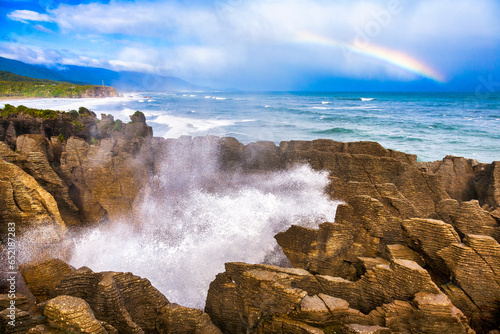 Putai blowhole at the famous Pancake Rocks, Rainbow over sea at Dolomite Point, near Punakaiki, West Coast, South Island of New Zealand. This area is a major tourist destination of the area.
