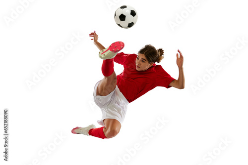 Dynamic image of young sportive girl in motion, football player kicking ball in jump isolated over white background © Lustre