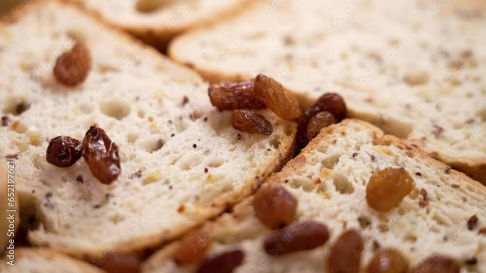 Fresh cereal gluten free sliced bread with falling dried raisins close up. Slow motion. Healthy dietary food Fresh cereal gluten free sliced bread with falling dried raisins close up. Slow motion. Healthy dietary food