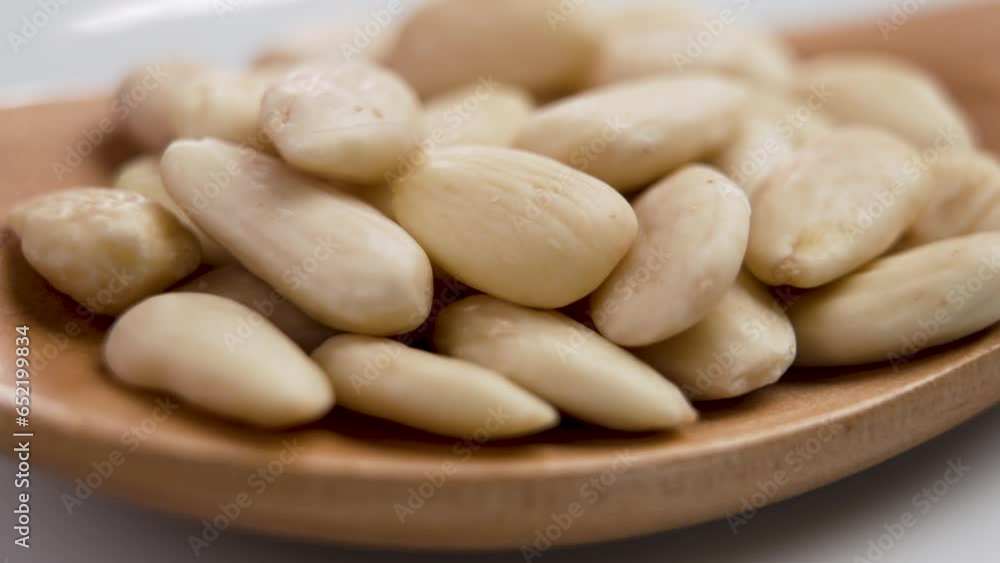 A full wooden spoon of shelled light almonds. Close up. Rotation A full wooden spoon of shelled light almonds. Close up. Rotation
