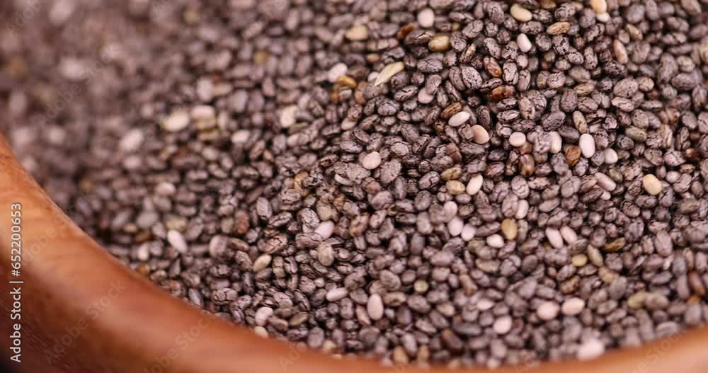 raw chia seeds rich in vitamins and minerals, small chia seeds in a wooden bowl raw chia seeds rich in vitamins and minerals, small chia seeds in a wooden bowl