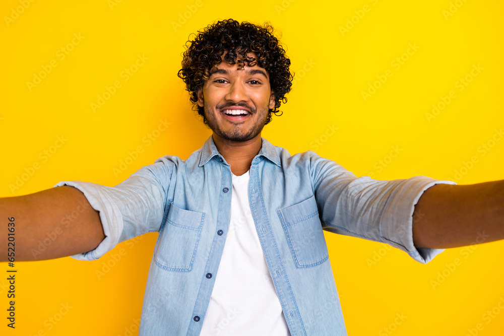 Portrait of cheerful nice young man beaming smile make selfie recording video isolated on yellow color background Portrait of cheerful nice young man beaming smile make selfie recording video isolated on yellow color background