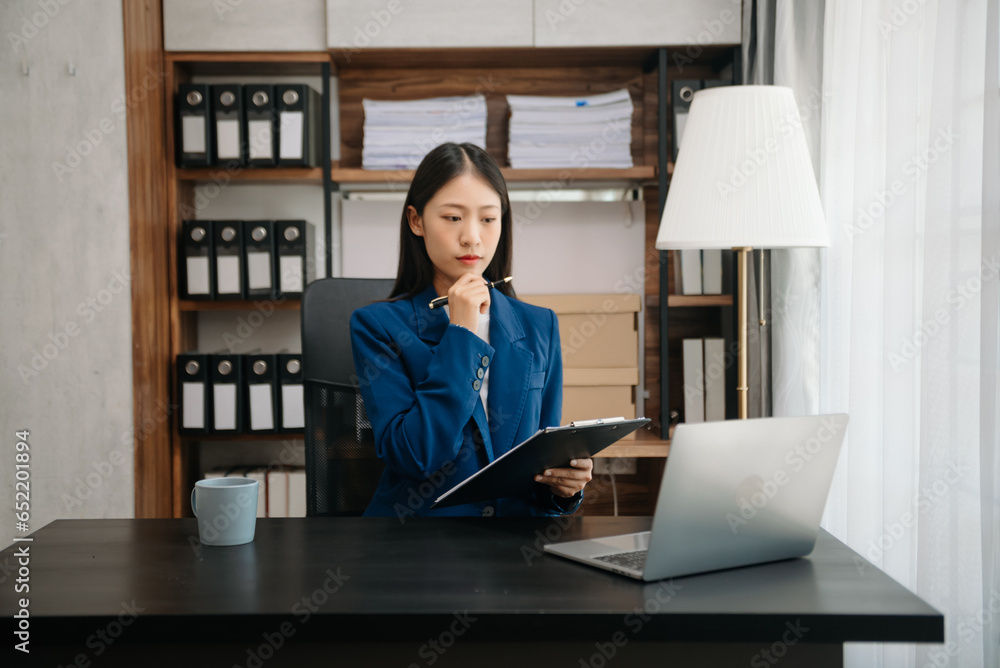 Business woman using tablet and laptop for doing math finance on an office desk, tax, report, accounting, statistics, and analytical research concept