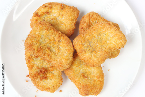 Chicken nuget is served on a plate with a white background photo