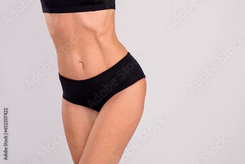 Cropped portrait of sportive great shape aged lady fit hips stomach empty space ad isolated on grey color background