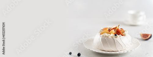 Meringue Pavlova cake banner. Anna Pavlova cake with peach, figs, blueberries and vanilla cream on a white background. Web line, copy space. Summer meringue dessert recipe, menu. Confectionery menu