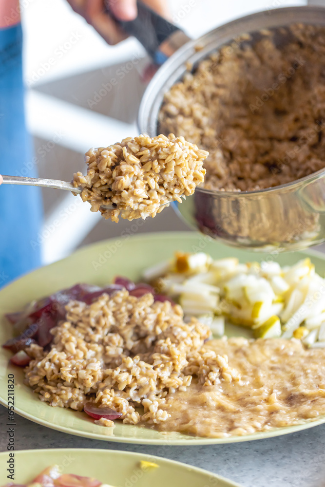 A woman prepares oatmeal with fruits, close-up. A woman prepares oatmeal with fruits, close-up.