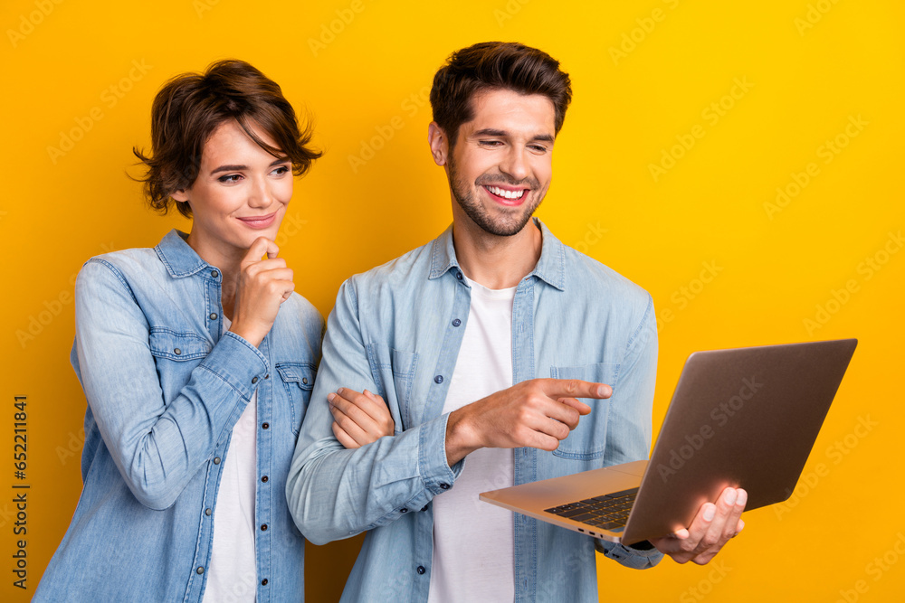 Photo of two workers working netbook writing project pointing screen isolated bright color background Photo of two workers working netbook writing project pointing screen isolated bright color background