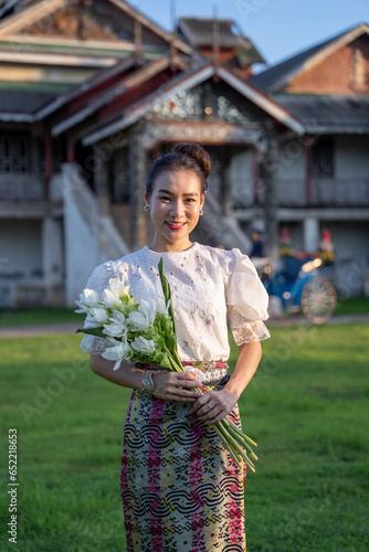 Women dressed in Burmese clothing and horse-drawn carriage at an ancient Burmese Temple, Wat Chaiyamongkol (Jong Kha). historical evidence of Burmese art in Lampang, Thailand. photo