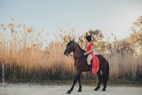 Cheerful woman riding horse in countryside