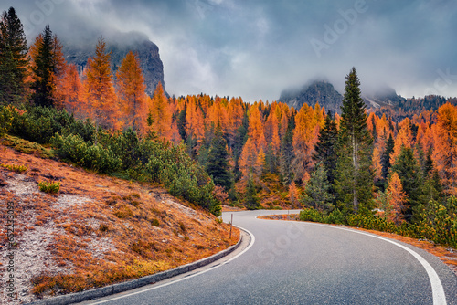 Fototapeta Naklejka Na Ścianę i Meble -  Dramatic morning view of National Park Tre Cime di Lavaredo with asphalt road. Gloomy autumn landscape in Dolomite Alps, South Tyrol, Location Auronzo, Italy, Europe. Traveling concept background..