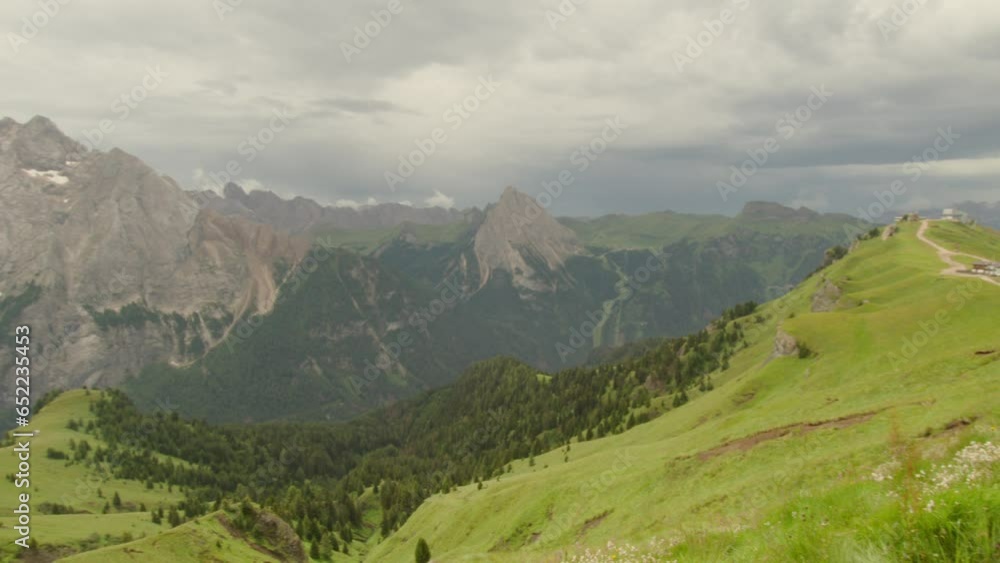 wide pan of the amazing dolomites in the alps Italy. Green grass in the summer and high rocky mountains with incredible views in 4K. Overcast cloudy. wide pan of the amazing dolomites in the alps Italy. Green grass in the summer and high rocky mountains with incredible views in 4K. Overcast cloudy.