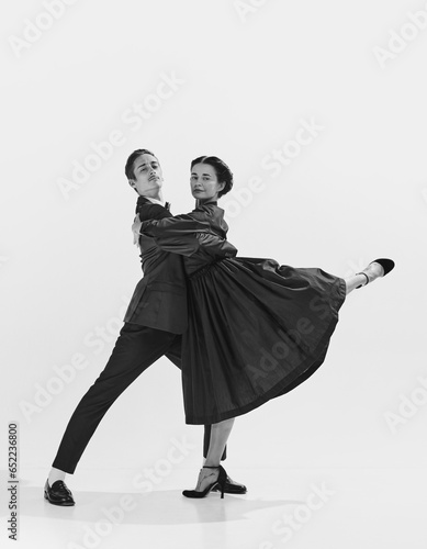 Canvas Print Talented and artistic young man in suit and beautiful woman in elegant dress dancing lindy hop