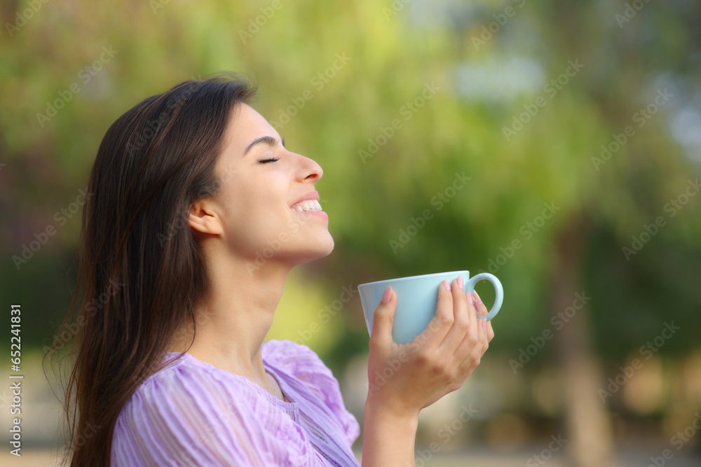 Happy woman drinking and breathing in a park Happy woman drinking and breathing in a park
