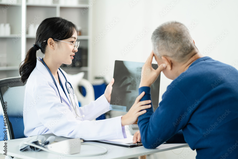 Female doctor consulting patient using x-ray film analyzed the results of medical reports, talking to patient and touching patient hand and consoling. Female doctor consulting patient using x-ray film analyzed the results of medical reports, talking to patient and touching patient hand and consoling.