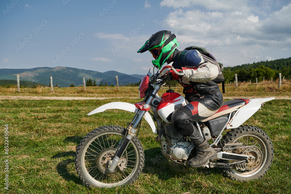 A motorcyclist equipped with professional gear, rides motocross on perilous meadows, training for an upcoming competition. A motorcyclist equipped with professional gear, rides motocross on perilous meadows, training for an upcoming competition.