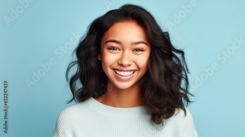 A vivacious teenager showcases her infectious laughter against a clean, well-lit studio background.
