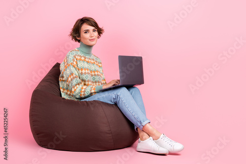 Full body length cadre of sit dormitory pouf young woman student remote online laptop education college isolated on pink color background