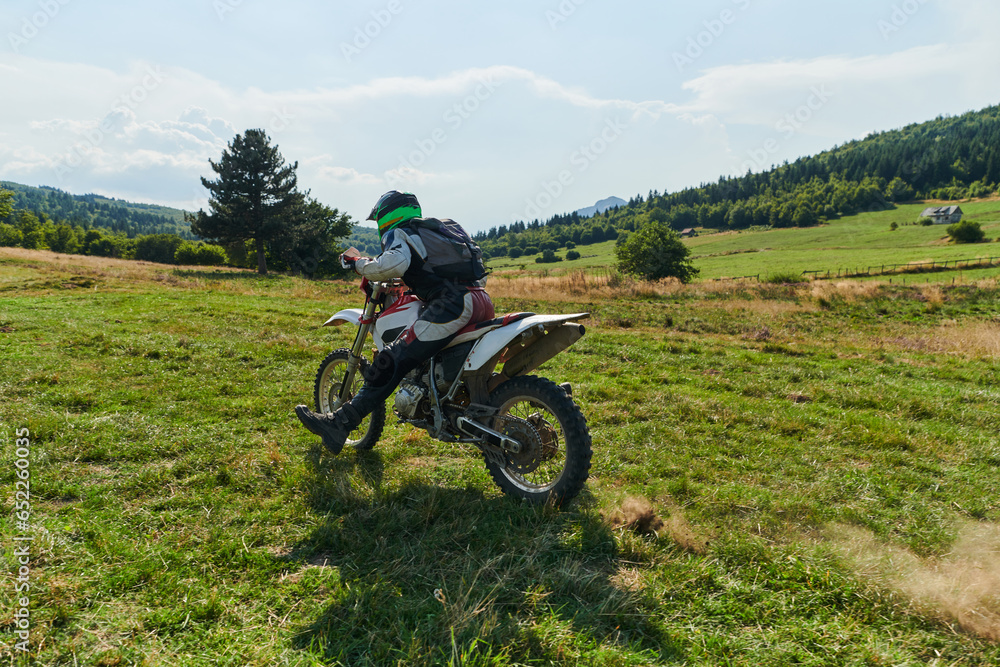 A motorcyclist equipped with professional gear, rides motocross on perilous meadows, training for an upcoming competition. A motorcyclist equipped with professional gear, rides motocross on perilous meadows, training for an upcoming competition.