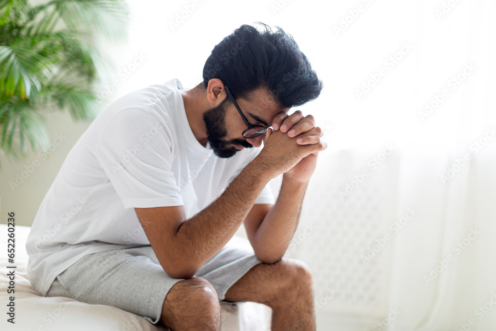 Obraz premium Impotence Concept. Upset Pensive Young Indian Man Sitting On Bed At Home