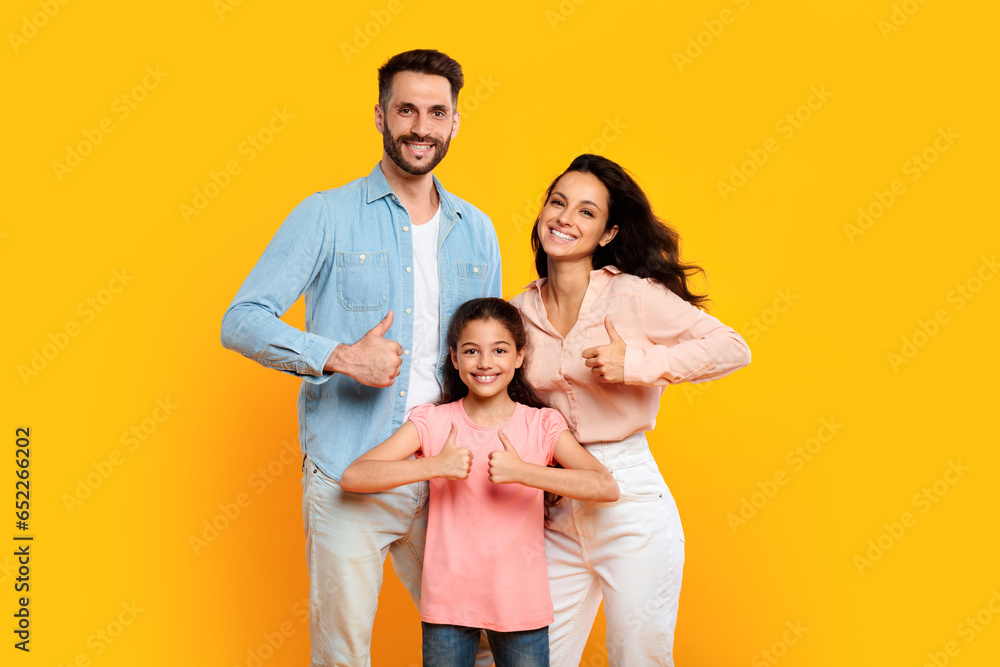We like it. Portrait of smiling european family of three showing thumbs up gesture, approving or recommending something We like it. Portrait of smiling european family of three showing thumbs up gesture, approving or recommending something