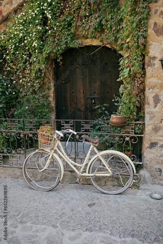 Vintage-looking bicycle parked outside a classic Italian-style house, with colorful shutters