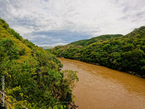 Tranquil Colombia magdalena river flows down a picturesque hillside surrounded by lush trees