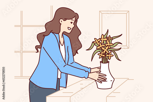 Woman does home staging and puts vase of flowers on table to prepare apartment for sale or rent. Girl designer provides home staging services for property owners wishing to make good deal