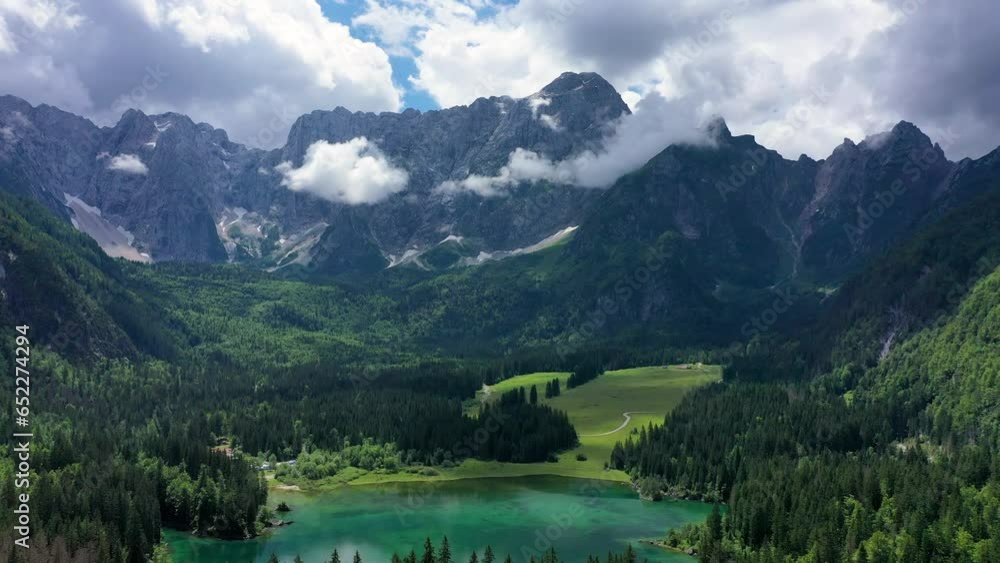 Picturesque lake Lago Fusine in Italy. Fusine lake with Mangart peak on background. Popular travel destination of Julian Alps. Location: Tarvisio comune , Province of Udine, Italy, Europe. Picturesque lake Lago Fusine in Italy. Fusine lake with Mangart peak on background. Popular travel destination of Julian Alps. Location: Tarvisio comune , Province of Udine, Italy, Europe.