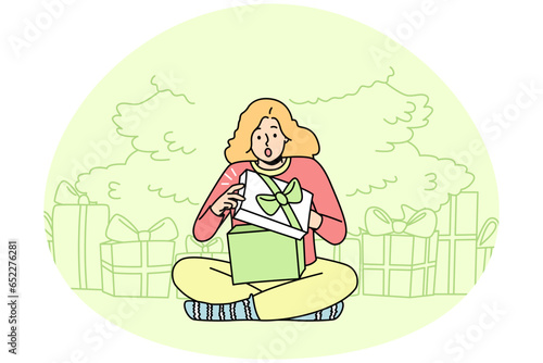 Happy child sitting near fir-tree open presents on Christmas Eve. Smiling kid feel joyful unpacking gift boxes for New Year. Winter holidays. Vector illustration.