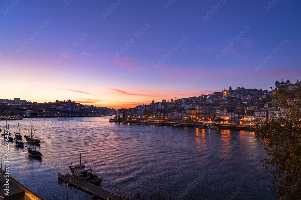 Picturesque sunset view of the harbor featuring a variety of boats and houses on the shore