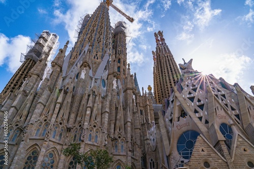 Low-angle shot of the La Sagrada Familia basilica in Barcelona, Spain against a blue sky