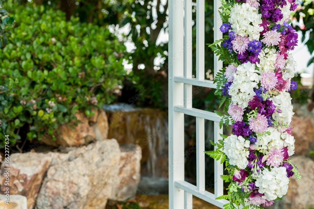 purple and white flowers adorn the outside of the arbor