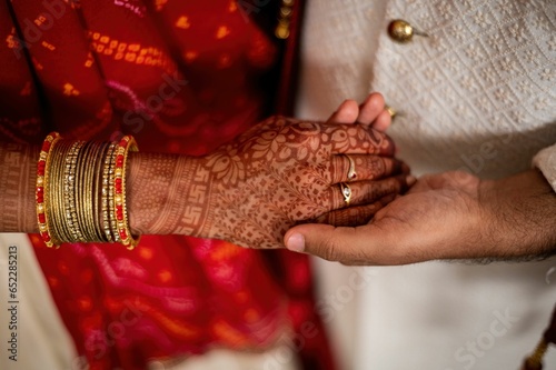 Closeup of Indian marriage couple hands with henna and jewelry