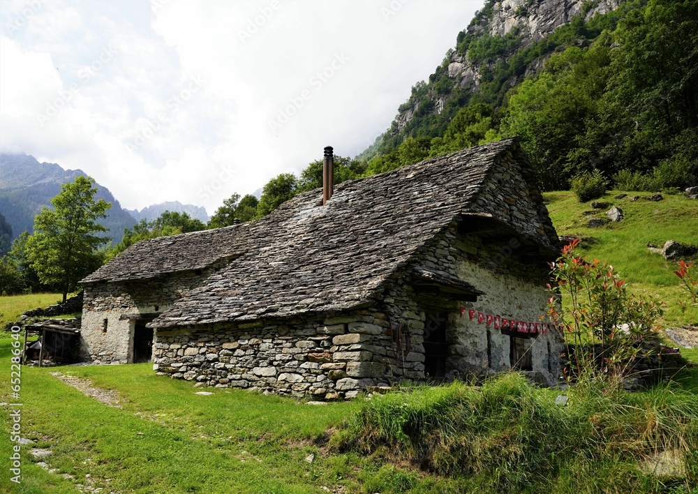 Aged, traditional house located in a rural setting, featuring a view of lush grassy hills Aged, traditional house located in a rural setting, featuring a view of lush grassy hills